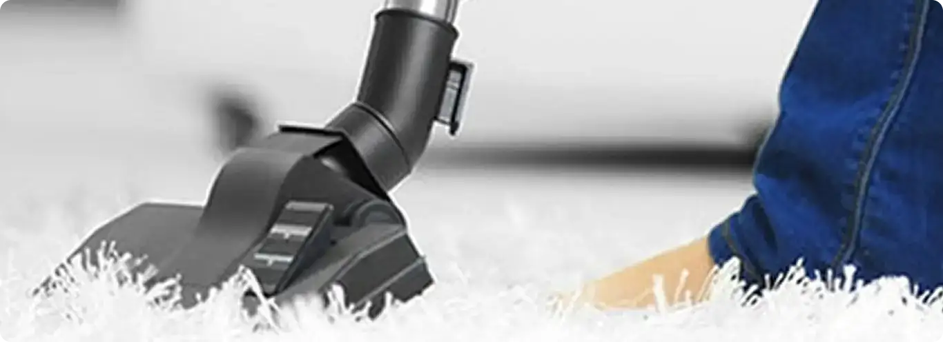 Close-up of a professional vacuuming a white carpet in Waterford.